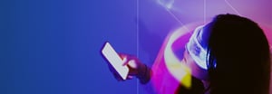 A woman wearing virtual reality glasses and holding a cell phone